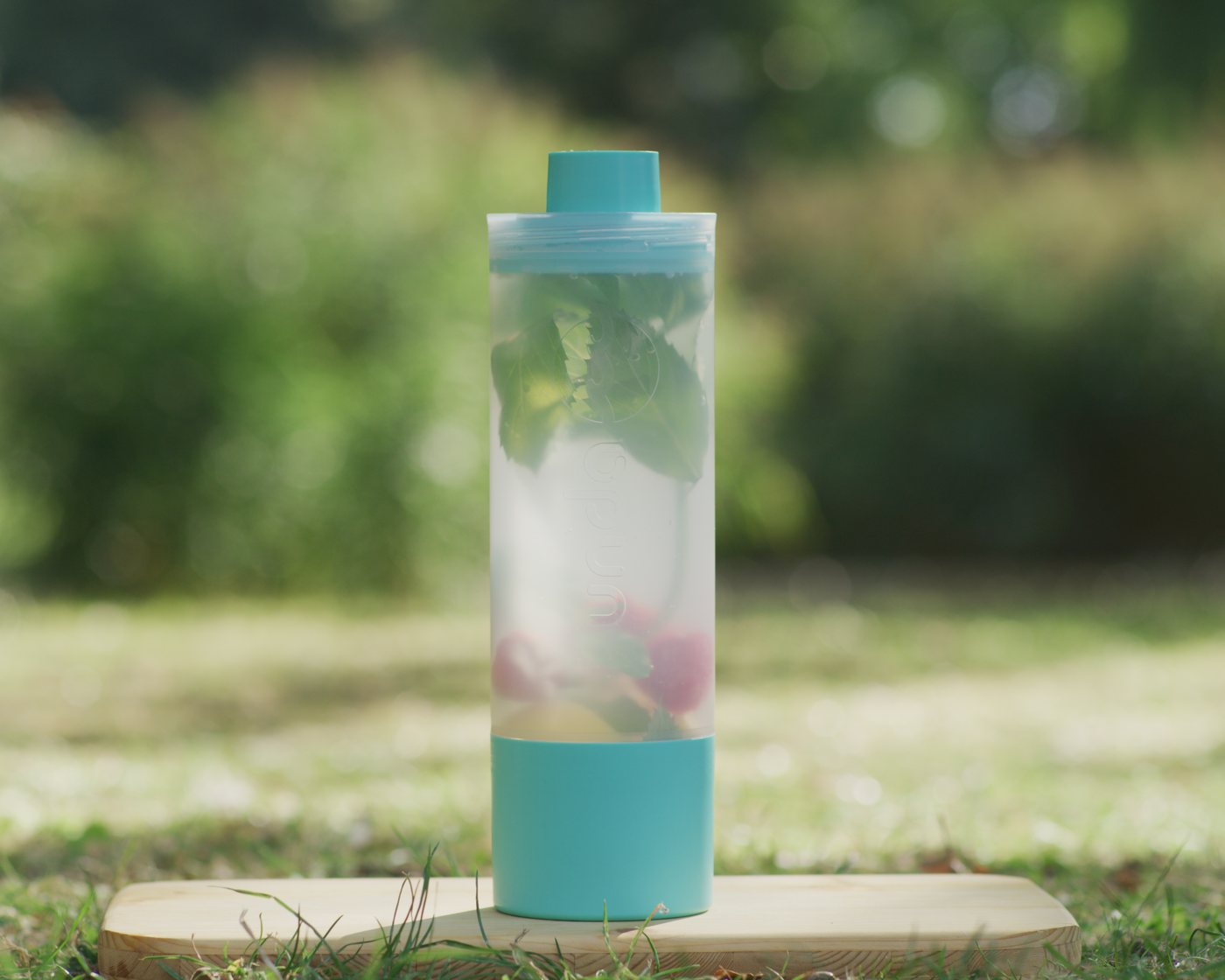 Die UNDA mit Infused Water auf einem Holzbrett im Gras