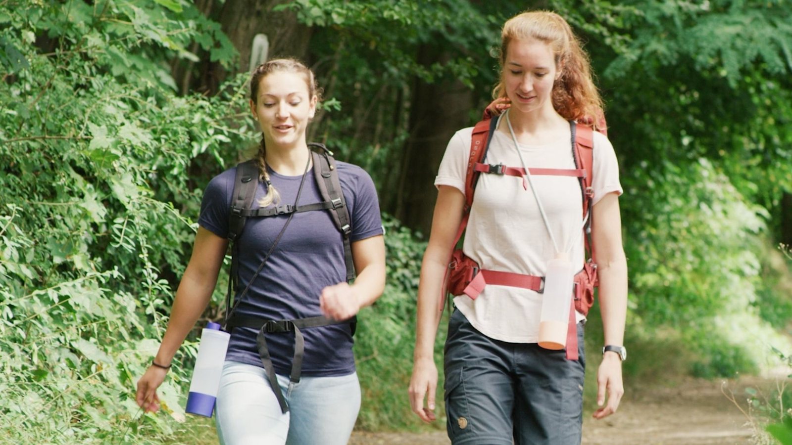 Zwei Wanderinnen mit der UNDA am Gürtel auf einem Waldweg